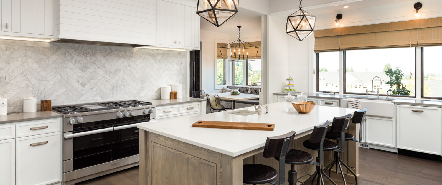 beautiful kitchen in new luxury home with island and pendant light fixtures